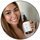 A customer smiling with a bottle of Cousin May's in a good review.